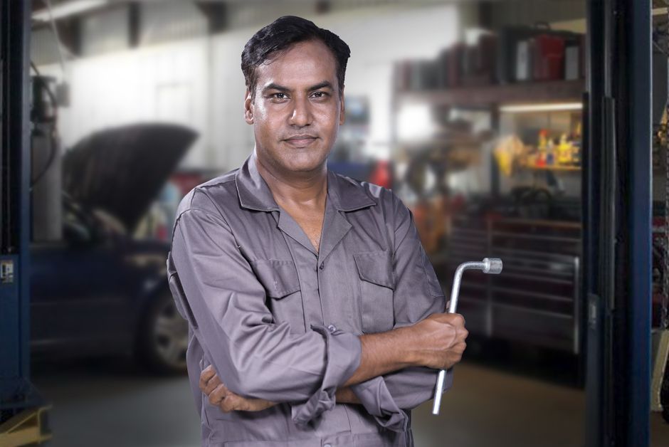 Experienced mechanic inspecting a vehicle's tire in a modern auto shop