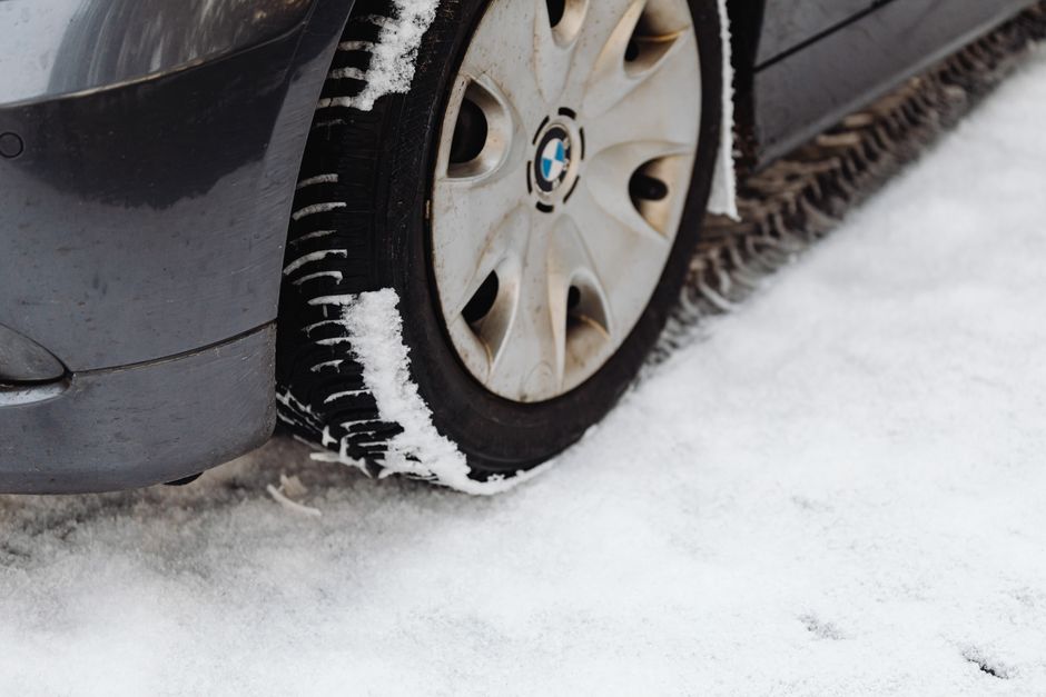Technician checking tire tread depth during a rotation service